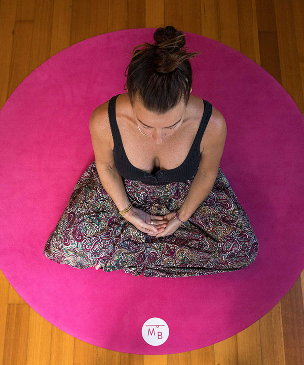 Woman sitting on a round yoga meditation mat